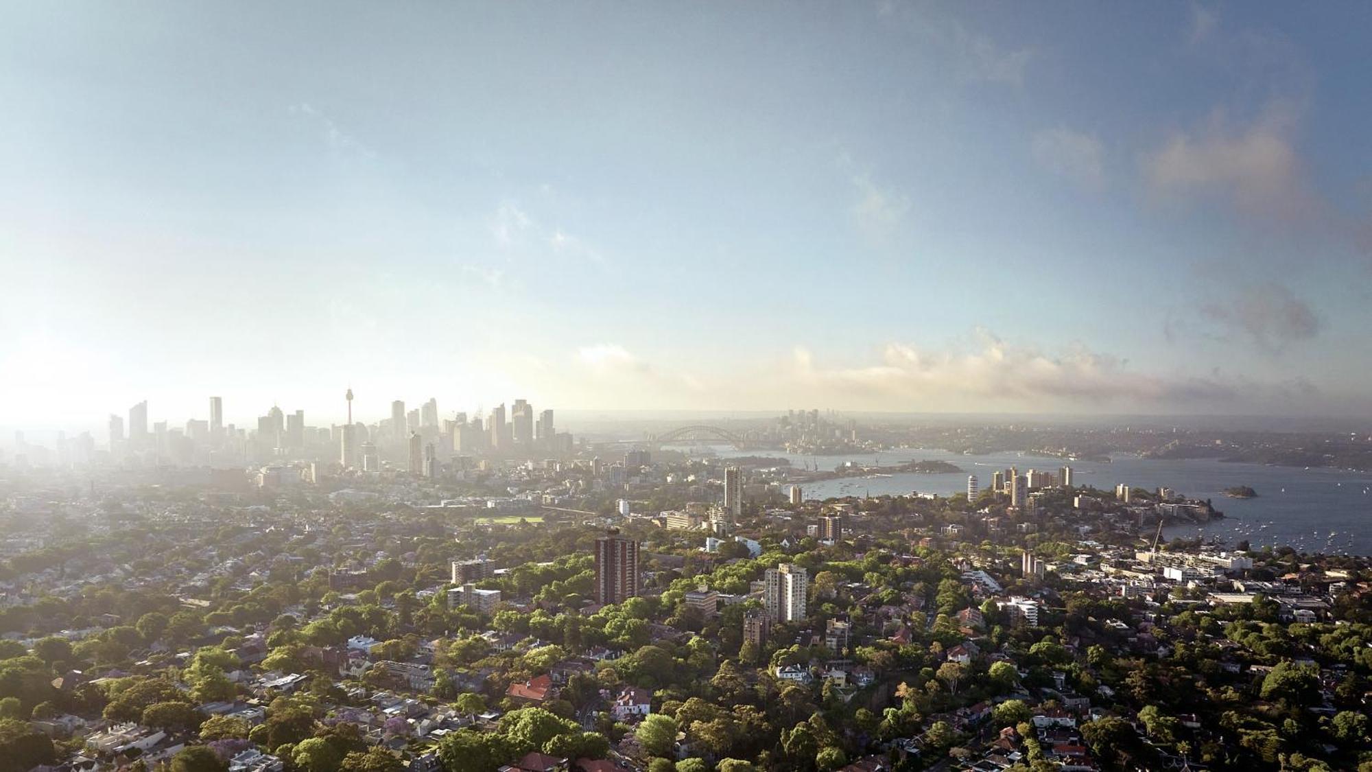 Meriton Suites Bondi Junction Sydney Luaran gambar The photo shows a panoramic view of a city skyline, likely taken from a high vantage point. In the foreground, there are lush green trees and buildings, suggesting a suburban area. As the view extends towards the background, tall skyscrapers dominate